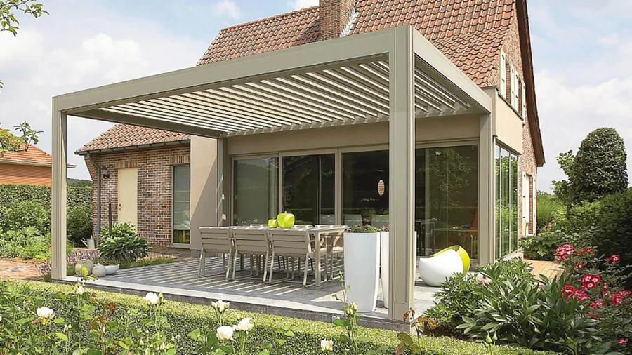 Světlá pergola u cihlového domu.